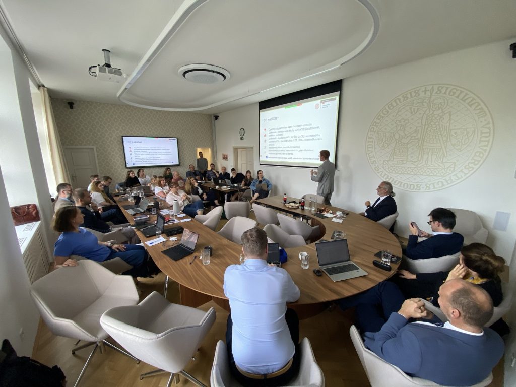 Faculty and students in discussion around a seminar table at Charles University
